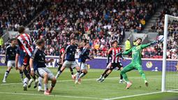 Kiper Manchester United, Altay Byindir (kanan) gagal menghalau bola tendangan pemain Brentford, Mikkel Damsgaard dalam laga lanjutan Liga Inggris 2024/2025 di Gtech Community Stadium, London, Inggris, Minggu (04/05/2025) waktu setempat. (AFP/Justin Tallis)