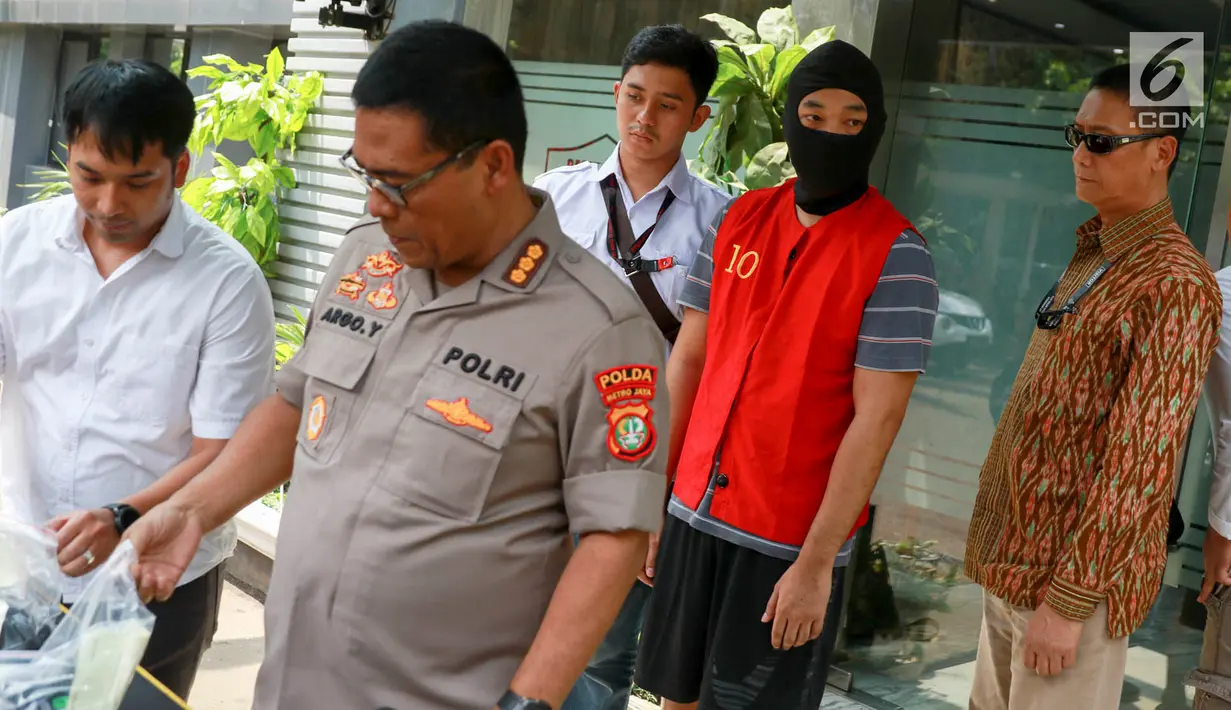 Tersangka kasus skimming ATM Ramyadjie Priambodo saat akan dilimpahkan ke kejaksaan di Polda Metro Jaya, Jakarta, Kamis (25/4). Pelimpahan tahap dua dilakukan usai kejaksaan menetapkan berkas perkara Ramyadjie lengkap (P-21) secara materiil dan formil pada 18 April 2019. (Liputan6.com/Immanuel Anton