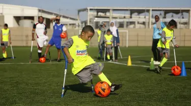 Seorang anak Palestina yang diamputasi menggiring bola saat berlatih di lapangan bermain al-Durra di kota Dier al-Balah, Jalur Gaza tengah (18/10/2019). Tim ini diawasi oleh pelatih Irlandia yang diamputasi Simon Baker.  (AP Photo/Hatem Moussa)