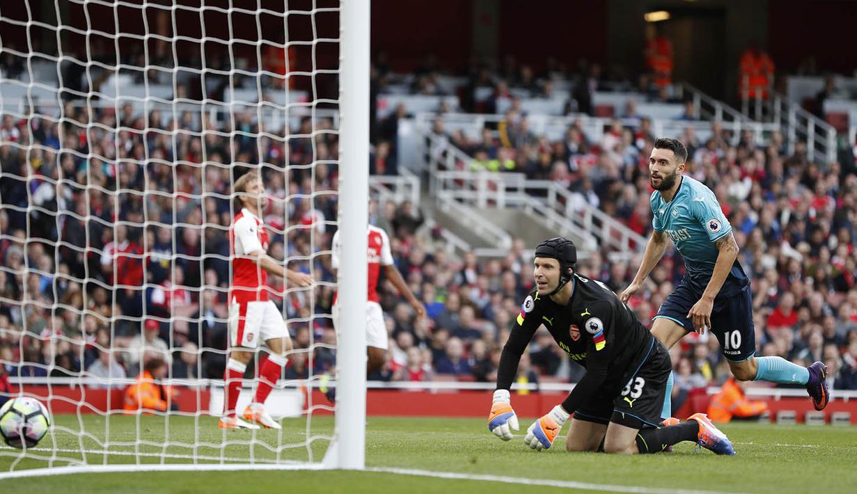 Kiper Arsenal, Petr Cech, kebobolan oleh gelandang Swansea, Borja Baston, pada laga Premier League di Stadion Emirates, London, Sabtu (15/10/2016). Arsenal menang 3-2 atas Swansea. (Reuters/John Sibley)
