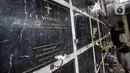 Penjaga membersihkan makam bersusun atau kolumbarium di kompleks pemakaman Paroki Gereja St Servatius, Kampung Sawah, Bekasi, Jawa Barat, Kamis (26/12/2019). (merdeka.com/Iqbal Nugroho)