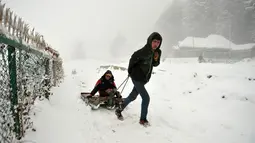 Seorang turis India ditarik melewati jalan yang tertutup salju di Gulmarg, sekitar 55km sebelah utara Srinagar, Kashmir, Selasa (3/1). Gelombang dingin yang melanda Kashmir kian parah hingga mencapai suhu di bawah nol derajat celcius (Tauseef Mustafa/AFP)