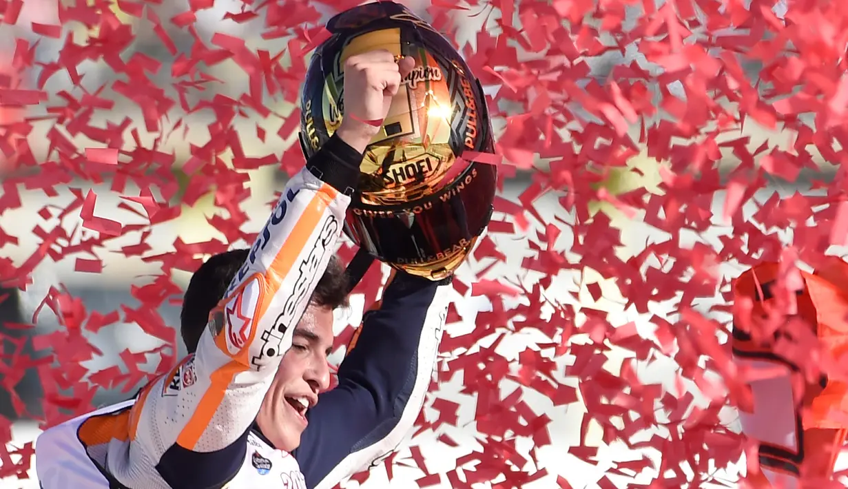 Pembalap Spanyol Repsol Honda, Marc Marquez mengangkat trophy setelah memenangkan balapan seri ke 18 MotoGP Grand Prix Valencia di Sirkuit Ricardo Tormo, Valencia (12/11). (AFP PHOTO / Jose Jordan)