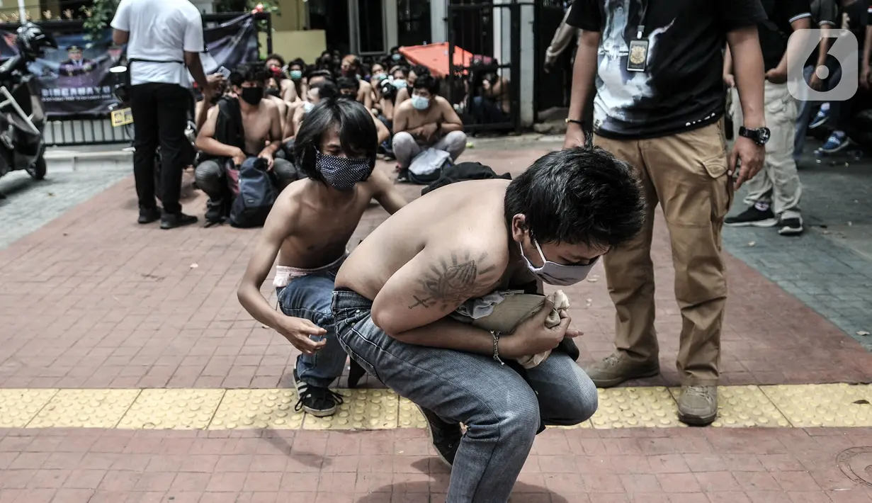 Massa pelajar dan remaja berjalan jongkok saat digiring ke mobil tahanan menuju Polda Metro Jaya di Polsek Subsektor Palmerah, Jakarta, Kamis (8/10/2020). Mereka diringkus polisi saat hendak menuju gedung DPR untuk mengikuti unjuk rasa bersama buruh dan mahasiswa. (merdeka.com/Iqbal Nugroho)
