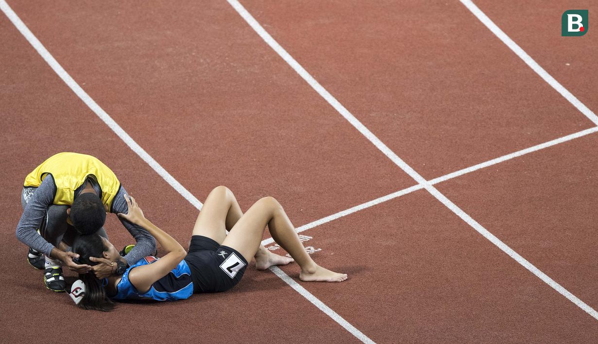 Pemandu Wannaruemon Kewalin mencoba menghibur karena hanya meraih medali perunggu di cabang para atletik nomor lari 400 meter putri klasifikasi T11 pada Asian Para Games 2018, di Stadion Utama Gelora Bung Karno Jakarta, Kamis(11/10/2018).  (Bola.com/Peksi