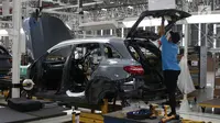Pekerja menyelesaikan perakitan mobil Mercedes Benz di Pabrik Mercedes Benz, Wanaherang, Bogor (11/12). Mercededes-Benz C-Class generasi terbaru kini resmi masuk jalur produksi pabrik Mercedes-Benz di Wanaherang, Bogor. (Liputan6.com/Herman Zakharia)