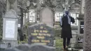 Seorang wanita berjalan di sebuah pemakaman Yahudi di Strasbourg, Prancis (17/12). Sebanyak 37 batu nisan dirusak dengan lambang swastika Nazi yang dicat semprot dan grafiti lainnya. (AFP Photo/Sebastien Bozon)
