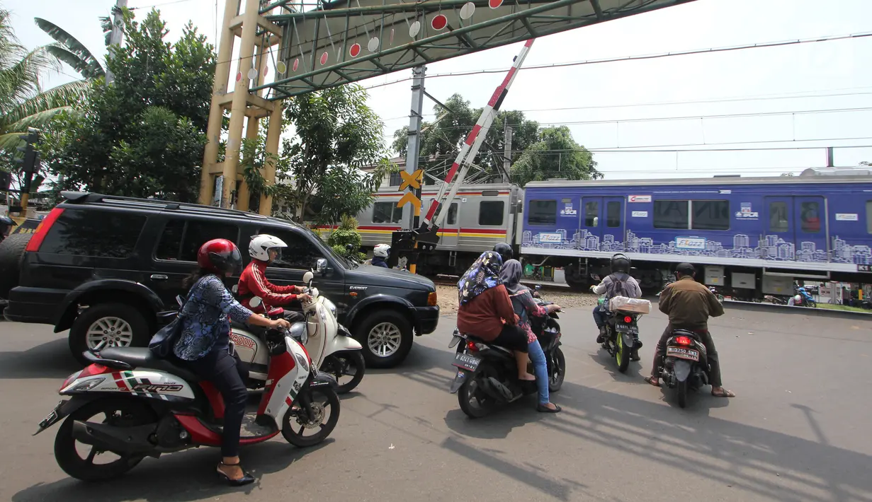 Sejumlah kendaraan berhenti di pintu perlintasan kereta api Bintaro Permai yang tidak berfungsi di Jakarta, Kamis (25/10). Kondisi tersebut sangat membahayakan pengendara yang melintas. (Liputan6.com/Angga Yuniar)