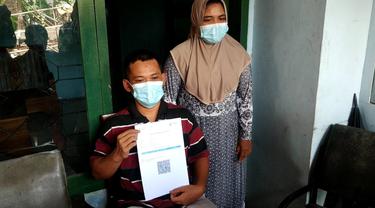 Joko Santoso menunjukkan sertifikat vaksin miliknya.  (Zainul Arifin/Liputan6.com)