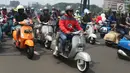 Gubernur DKI Jakarta Anies Baswedan berboncengan dengan anaknya melakukan konvoi bersama komunitas Vespa di kawasan TB Simatupang, Minggu (28/4/2019). Anies konvoi keliling Jakarta untuk merayakan ulang tahun ke-73 komunitas Vespa bertajuk "Vespa Still Fun n Running". (Liputan6.com/Angga Yuniar)