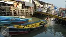 Seorang warga mengayuh sampannya di Kampung Aquarium, Jakarta Utara, Senin (28/3). Warga mengaku resah atas rencana Pemprov DKI Jakarta yang akan menggusur wilayah mereka. (Liputan6.com/Gempur M Surya)