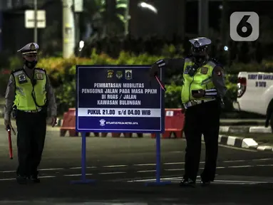 Polisi berjaga saat pemberlakuan pembatasan mobilitas warga guna menekan penyebaran COVID-19 di Jakarta, Selasa (22/6/2021). Pembatasan dilakukan karena meningkatnya jumlah kasus positif COVID 19 di Ibu Kota. (Liputan6.com/Johan Tallo)