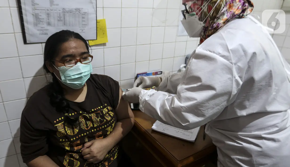 Petugas medis menyuntikkan vaksin COVID-19 Sinovac kepada tenaga kesehatan di Puskesmas Palmerah, Jakarta, Kamis (28/1/2021). Pemberian vaksin COVID-19 tahap kedua dilaksanakan terhadap tenaga kesehatan mulai hari ini. (Liputan6.com/Johan Tallo)