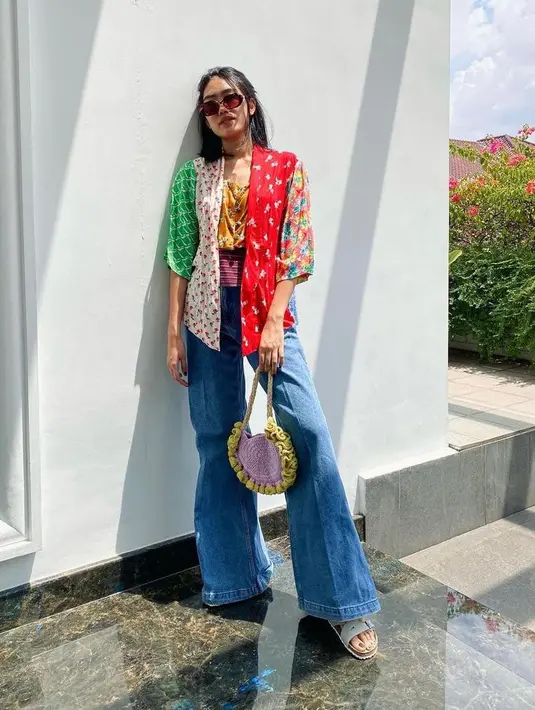 Pakai kebaya dengan mixed pattern yang colorful dan dipadukan dengan flare jeans, sunnies, dan crochet bag bisa memberikan sentuhan gaya retro pada casual look-mu. (Instagram/alikaislamadina).