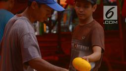 Pedagang timun suri merapikan dagangannya di Pasar Induk Kramat Jati, Jakarta, Rabu (23/5). Pedagang menjual timun seharga Rp 7 ribu per kilogram. (Merdeka.com/Imam Buhori)