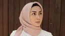 Istri Arie Untung, Fenita Arie saat berpose dengan mengenakan hijab pink dan baju berwarna putih. Langkah Fenita hijrah mengenakan hijab pertama kali diketahui dari unggahan sang suami. (Instagram/ariekuntung)