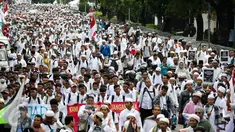 Massa demo 2 Desember mulai berjalan kaki menuju Monumen Nasional (Monas), Jakarta Pusat, Jumat (2/12). Dengan mengenakan pakaian serba putih, peserta demo 2 Desember sesekali mengucapkan kalimat takbir. (Liputan6.com/Faizal Fanani)