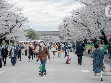 Para pengunjung menikmati sakura mekar di Taman Ueno, Tokyo, Sabtu (25/3/2023). Memasuki musim semi di Jepang, warga hingga turis mancanegara berbondong-bondong menikmati keindahan dari bunga sakura yang mekar. (Liputan6.com/Faizal Fanani)