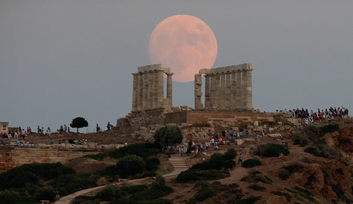 Bulan purnama hampir penuh yang menampakkan diri di langit Kuil Poseidon kuno di Cape Sounion, sekitar 70 kilometer sebelah tenggara Athena, Yunani (2/8/2020). (Xinhua/Marios Lolos)