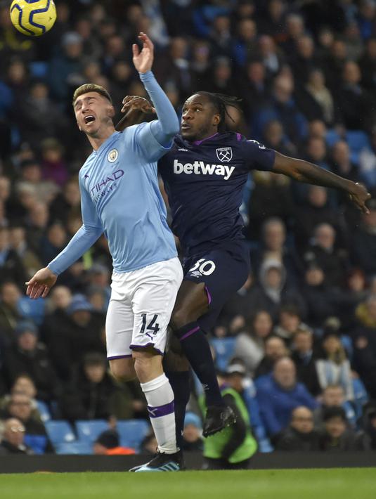 Bek Manchester City, Aymeric Laporte berebut bola dengan gelandang West Ham, Michail Antonio pada pertandingan lanjutan Liga Inggris di stadion Etihad di Manchester, Inggris, Rabu (19/2/2020). City menang atas West Ham 2-0. (AP Photo/Rui Vieira)