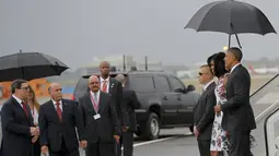 Presiden AS Barack Obama dan istrinya Michelle disambut Menlu Kuba, Bruno Rodriguez (kiri) setibanya di Bandara Internasional Havana, Minggu (20/3). Kunjungan Obama ini yang pertama dilakukan seorang presiden AS sejak 88 tahun lalu. (REUTERS/stringer)