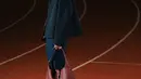 Marselino tampil dengan jaket hitam dipadukan bawahan celana denim sambil membawa handbag maroon. Dipadukan sneakers putihnya. [@kacastuudio]