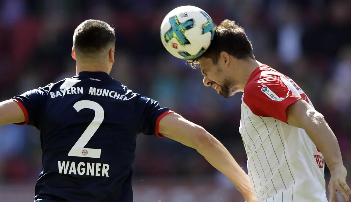 Striker Bayern Munchen, Sandro Wagner, duel udara dengan bek FC Augsburg, Rani Khedira, pada laga Bundesliga di WWK Arena, Augsburg, Sabtu (7/4/2018). Bayern Munchen menang 4-1 atas FC Augsburg. (AP/Matthias Schrader)