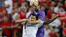 Gelandang Sevilla, Machin Vitolo (depan) berebut bola udara dengan bek Fiorentina Nenad Tomovic pada leg pertama semifinal Europa League di Stadion Ramon Sanchez, Kamis (7/5/2015). Sevilla menang 3-0 atas Fiorentina. (REUTERS/Marcelo del Pozo)