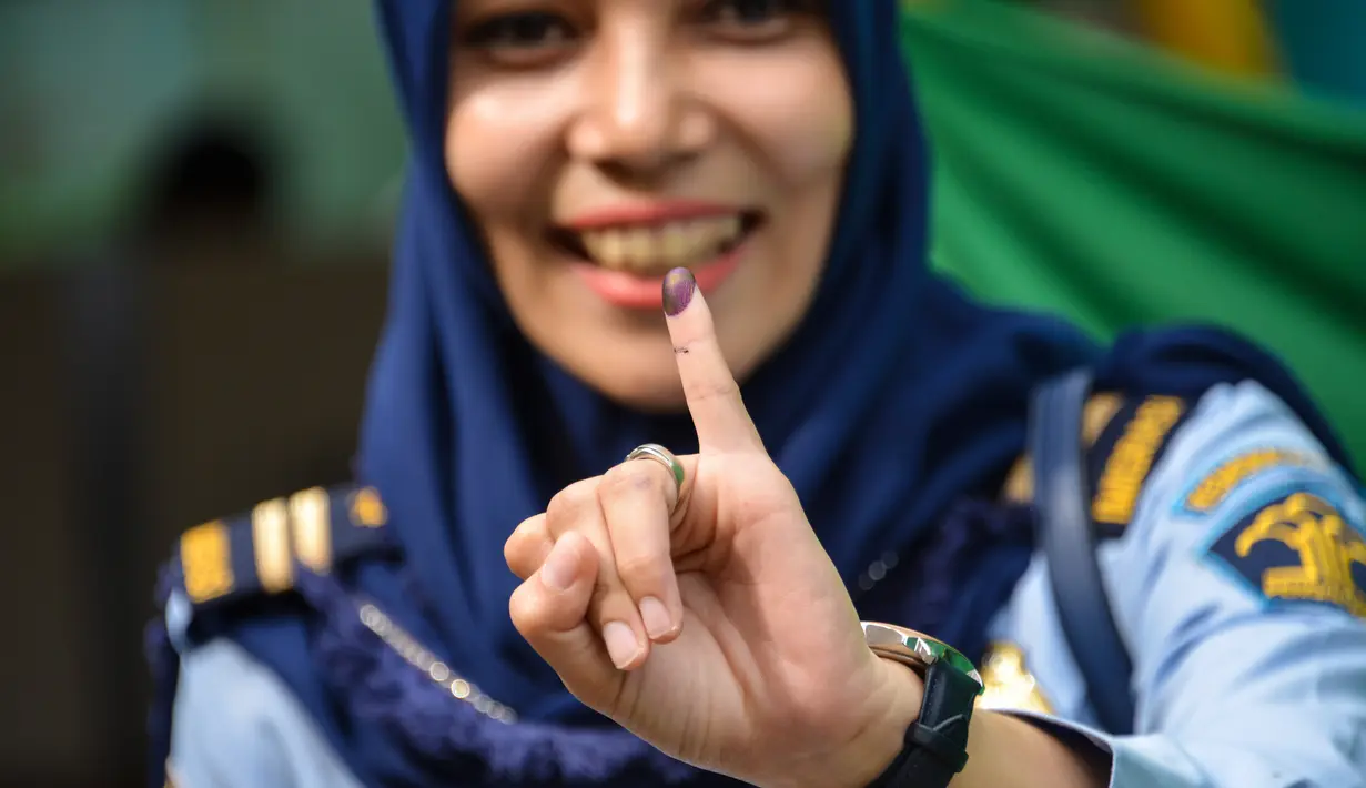 Warga menunjukkan jari kelingking usai mencoblos pada pemungutan suara ulang pemilu 2019 di TPS-6 Desa Lamteumen Timur, Banda Aceh, Aceh, Kamis (25/4). Pemungutan suara ulang karena adanya penggunaan formulir C6 pemilih yang telah meninggal pada pemilu 17 April lalu. (CHAIDEER MAHYUDDIN/AFP)