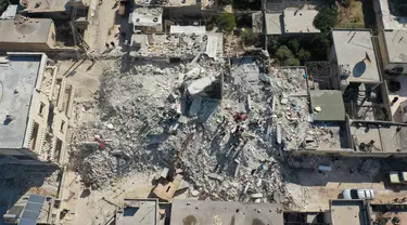 Sebuah foto udara menunjukkan puing-puing bangunan yang runtuh dan setengah runtuh di kota Jindayris, Suriah, Rabu (15/2/2023). Gempa bumi berkekuatan 7,8 magnitudo menghantam Turki dan Suriah pada 6 Februari lalu, menewaskan sedikitnya 40.000 orang serta menghancurkan sebagian besar wilayah Suriah dan Turki. (Omar HAJ KADOUR/AFP)
