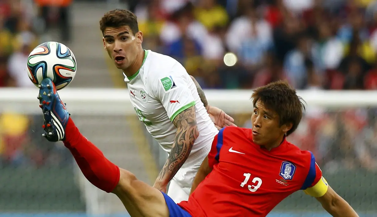 Gelandang Korea Selatan, Koo Ja-cheol (depan), berusaha melewati pemain belakang Aljazair, Carl Medjani, saat berlaga di penyisihan Piala Dunia 2014 Grup H di Stadion Beira Rio, Porto Alegre, Brasil (23/6/2014). (REUTERS/Damir Sagolj) 