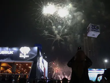 Pengunjung menyaksikan pesta kembang api di langit saat Jakarta Fair ke-53 atau Pekan Raya Jakarta (PRJ) di JiExpo Kemayoran, Jakarta Pusat, Selasa (21/6/2022) malam. Pesta kembang api menggelegar di kawasan PRJ bertepatan dengan HUT Jakarta yang jatuh pada besok, 22 Juni 2022. (Liputan6.com/Herman Zakharia)