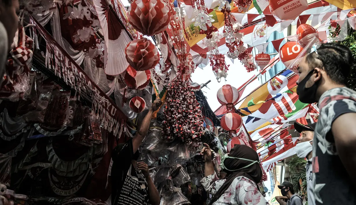 Pengunjung memilih pernak-pernik Hari Kemerdekaan di Pasar Jatinegara, Jakarta, Minggu (2/8/2020). Menjelang perayaan HUT ke-75 Republik Indonesia, Pasar Jatinegara mulai dipadati warga yang ingin mencari beragam pernak-pernik hiasan kemerdekaan. (merdeka.com/Iqbal Nugroho)
