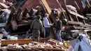 Warga memilah puing bangunan yang hancur diterjang tornado di Mayfield, Kentucky, Amerika Serikat, 11 Desember 2021. Selain menewaskan puluhan orang, tornado juga meluluhlantakkan rumah, pabrik. (AP Photo/Mark Humphrey)