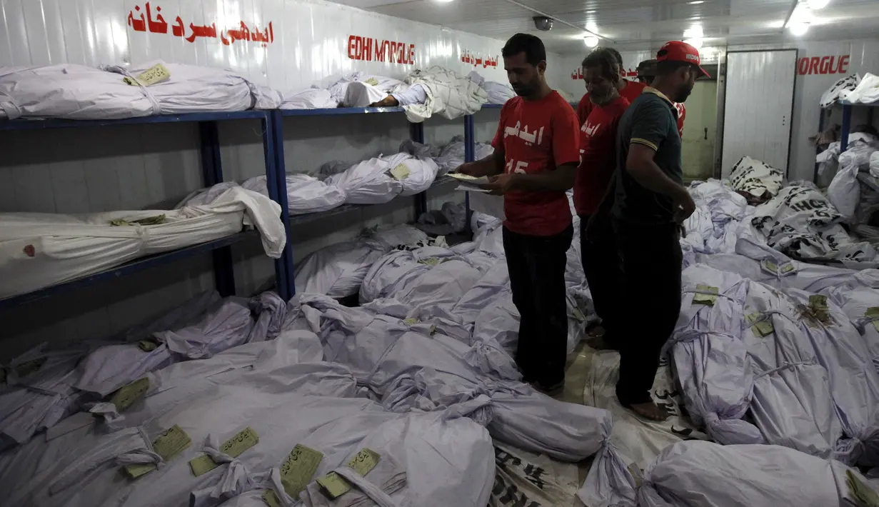 Relawan mencari salah satu jenazah korban gelombang panas, di sebuah kamar mayat di Karachi, Pakistan, Senin (22/6). Fenomena gelombang panas yang mendera Pakistan telah menewaskan setidaknya 120 orang. (REUTERS/Akhtar Soomro)