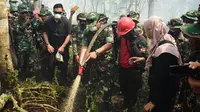 Panglima TNI Marsekal Hadi Tjahjanto meninjau dan ikut menyiram lahan terbakar di Bengkalis. (Liputan6.com/M Syukur)