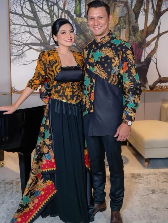 Titi Kamal mengenakan dress hitam dengan aksen batik pada atasan dan obinya, serta terlihat batik pun menjuntai pada bagian belakang. Christian Sugiono mengenakan batik berkerah agak tinggi dengan aksen hitam pada bagian bawah yang serasi dengan celana nya. [@titi_kamall]