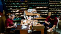 Para pekerja menyelesaikan pembuatan sepatu pointe di bengkel perusahaan Grishko, Moskow, Rusia, 25 Februari 2020. Sepatu buatan Grishko dijual ke seluruh dunia dan menghiasi panggung-panggung balet dunia. (Dimitar DILKOFF/AFP)