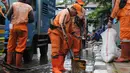 Tidak hanya petugas dari Dinas Sumber Daya Air (SDA) DKI Jakarta, beberapa personel dari Penanganan Prasarana dan Sarana Umum (PPSU) turut dikerahkan untuk menyapu dan membersihkan sisa lumpur yang mengendap di badan jalan. Tampak dalam foto, petugas Penanganan Prasarana dan Sarana Umum (PPSU) DKI Jakarta membersihkan sisa lumpur di Jalan Gunung Sahari Raya atau tepat di depan Mangga Dua Square, Jakarta, Selasa (13/1/2026). (merdeka.com/magang/Rendi Saputra)
