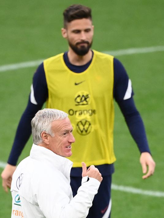 Pelatih Prancis, Didier Deschamps memberi isyarat di sebelah penyerang Prancis Olivier Giroud selama sesi latihan di Stadion Velodrome di Marseille, Prancis selatan (24/3/2022). Prancis akan bertanding melawan Pantai Gading pada pertandingan persahabatan. (AFP/Franck Fife)