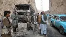 Warga Afghanistan memeriksa sisa-sisa truk yang hangus di sepanjang jalan raya, menyusul gempa bumi di Tang-e Tashkurgan, distrik Khulm, provinsi Samangan, pada Senin 3 November 2025. Gempa ini dikategorikan pada tingkat peringatan oranye, yang menandakan kemungkinan besar terjadinya korban jiwa dalam jumlah signifikan. (Atif Aryan/AFP)