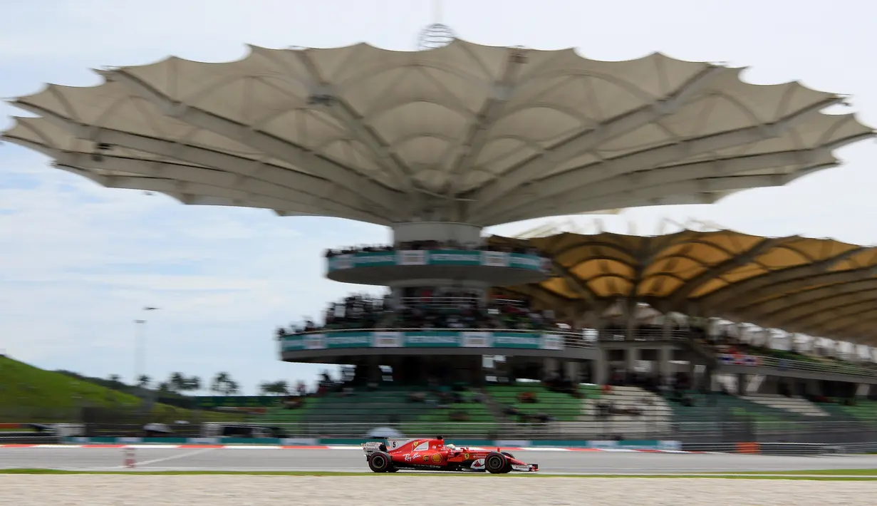 Aksi pebalap Ferrari, Sebastian Vettel melaju pada lintasan balapan Formula One Malaysia Grand Prix, Sepang, (01/10/2017). Vettel akhirnya finis pada posisi keempat. (AFP/Manan Vatsyayana)