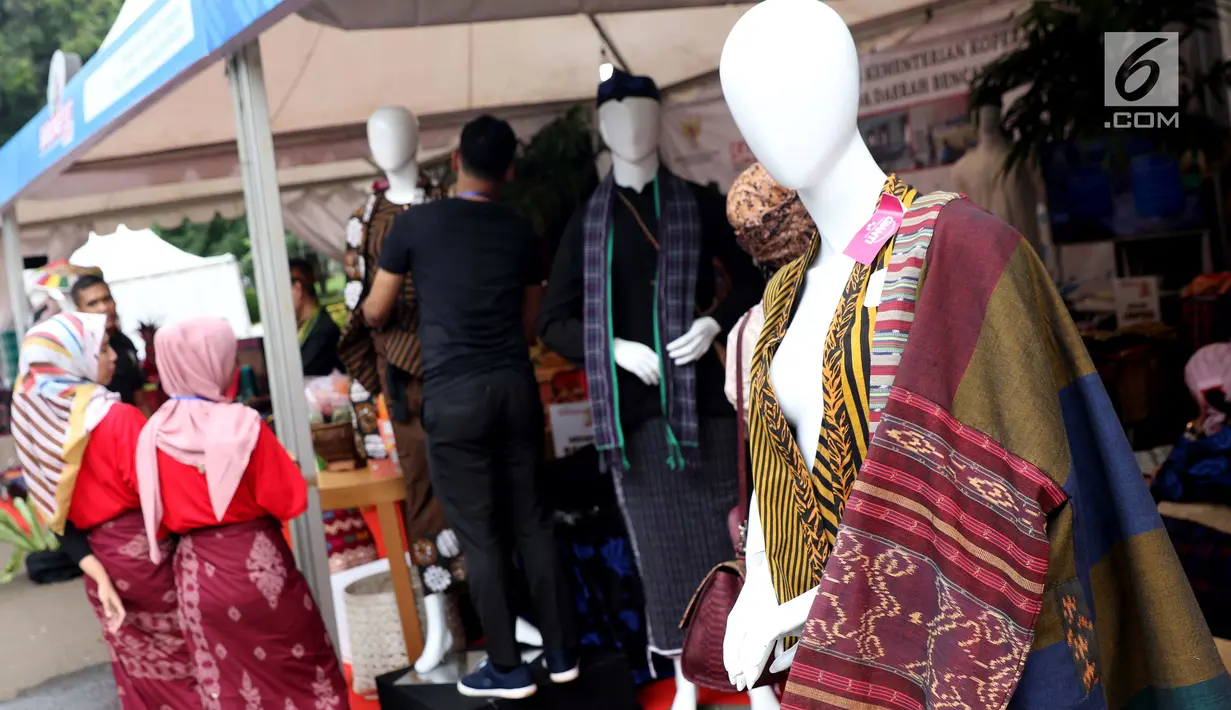 Pengunjung melihat-lihat produk kain tenun yang dipamerkan di Festival Sarung Indonesia 2019, Plaza Tenggara Kompleks GBK, Jakarta, Minggu (3/3). Festival ini diikuti sejumlah perajin sarung tenun dari berbagai daerah. (Liputan6.com/Helmi Fithriansyah)