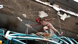 Petugas memeriksa puing-puing bekas ledakan di sebuah pabrik garmen di Dhaka, Bangladesh (4/7). insiden itu terjadi akibat ledakan mesin boiler di pabrik garmen Multifabs Limited. (AP Photo / AM Ahad)