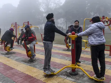 Orang-orang berolahraga di tengah kabut tebal selama hari yang dingin di sebuah taman di Amritsar, India (30/12/2019). India saat ini mengalami musim dingin dengan hari dingin terpanjang dalam 22 tahun terakhir. (AFP/Narinder Nanu)