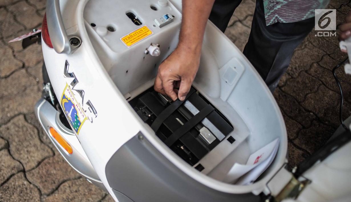 Petugas menunjukan tempat penyimpanan daya baterai motor listrik di Taman Marga Satwa Ragunan, Jakarta, Kamis (13/12). Pemprov DKI menerima hibahan 50 unit motor listrik Viar Q1. (Liputan6.com/Faizal Fanani)