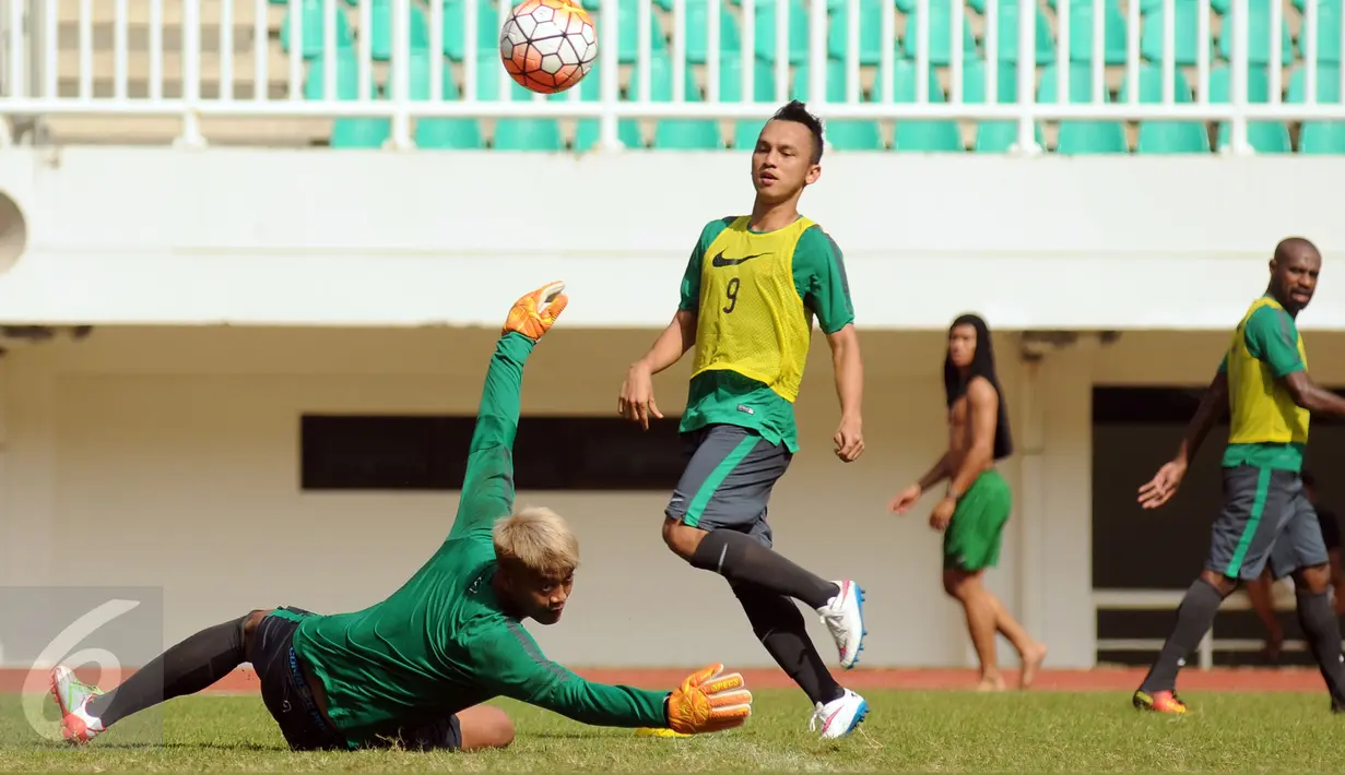 Kiper Arema Cronus, Kurnia Meiga (bawah) gagal menghalau bola saat mengikuti latihan seleksi timnas Indonesia di Stadion Pakansari, Kab Bogor, Selasa (9/8). Indonesia bakal berlaga di AFF Cup 2016. (Liputan6.com/Helmi Fithriansyah)