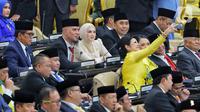 Penyanyi serta musisi, Ahmad Dhani dan Mulan Jameela saat rapat paripurna pelantikan anggota DPR Republik Indonesia terpilih periode 2024-2029 di Gedung Nusantara, Kompleks Parlemen, Senayan, Jakarta, Selasa (1/10/2024). Ahmad Dhani dan Mulan Jameela terpilih dari Partai Gerindra. Ahmad Dhani dari daerah pemilihan Jawa Timur I dengan perolehan suara sebanyak 134.227. Mulan Jameela dari daerah pemilihan Jawa Barat XI dengan perolehan suara sebanyak 83.526. (Liputan6.com/Angga Yuniar)