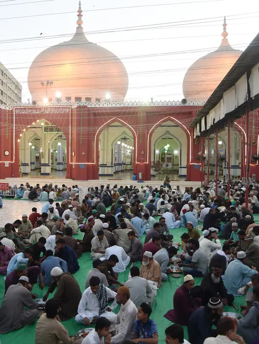 Umat Islam Pakistan berbuka puasa bersama di sebuah masjid di Karachi pada 7 Mei 2019. Ketika bulan suci Ramadan mulai di Pakistan, banyak masyarakat muslim memanfaatkan buka puasa gratis yang disponsori oleh badan-badan amal dan orang-orang kaya. (RIZWAN TABASSUM / AFP)