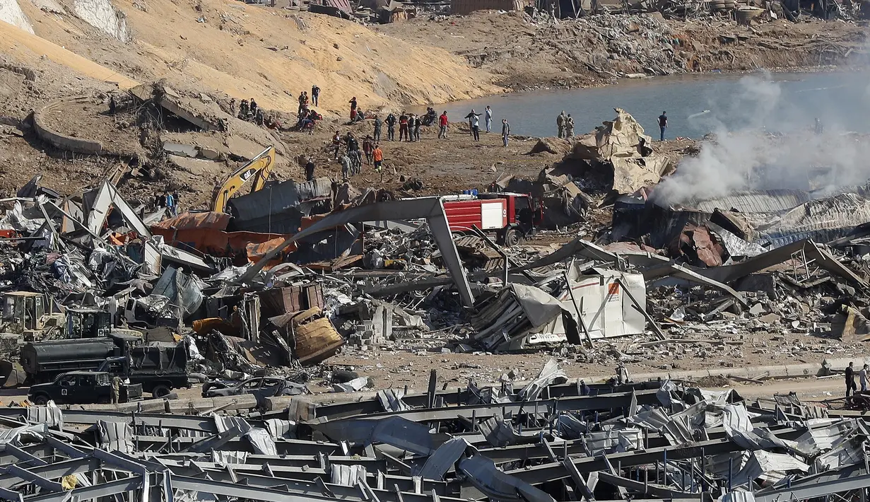 Petugas penyelamat dan keamanan bekerja di lokasi ledakan besar di Beirut, Lebanon, Rabu (5/8/2020). Ledakan yang mengakibatkan puluhan orang tewas dan ribuan lainnya terluka tersebut meratakan pelabuhan dan merusak bangunan di seluruh Beirut. (AP Photo/Hussein Malla)